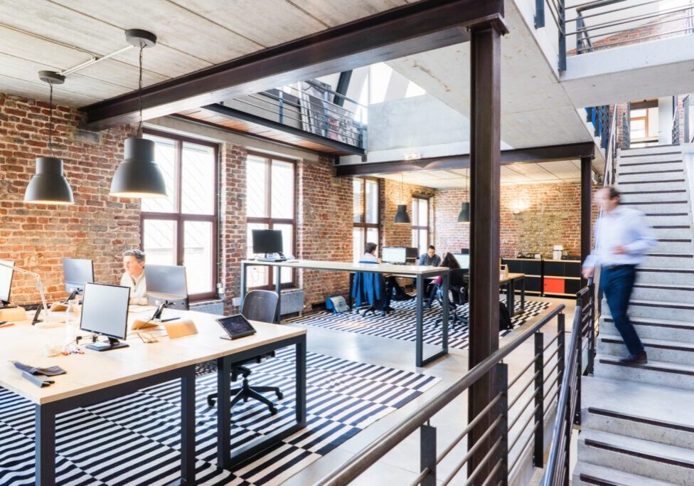 Industrial office with a stairway, large tables and chairs