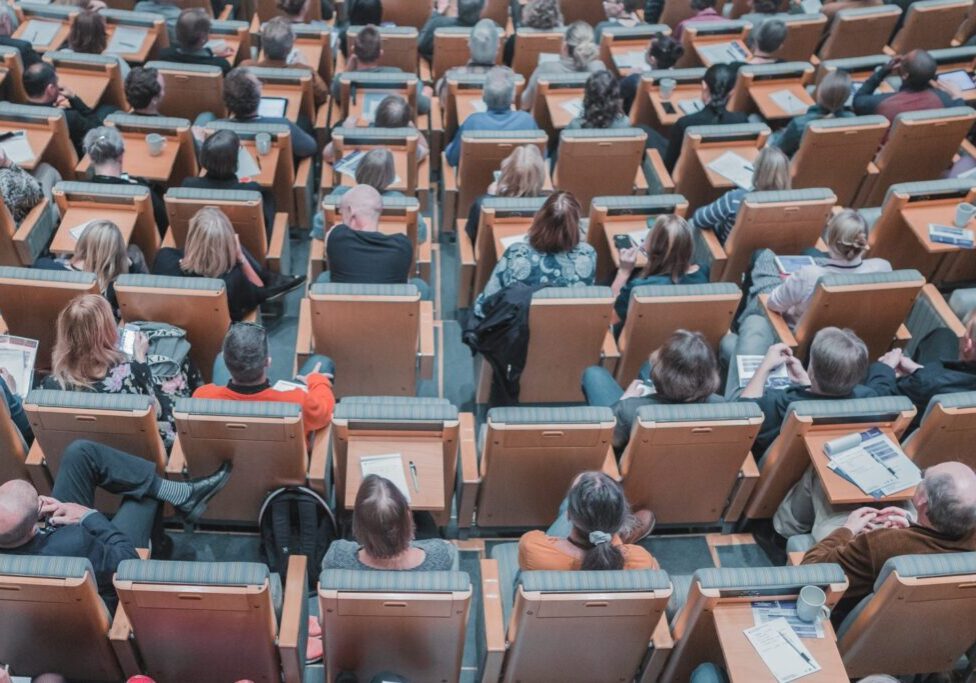 People sitting in a lecture hall as seen from the back