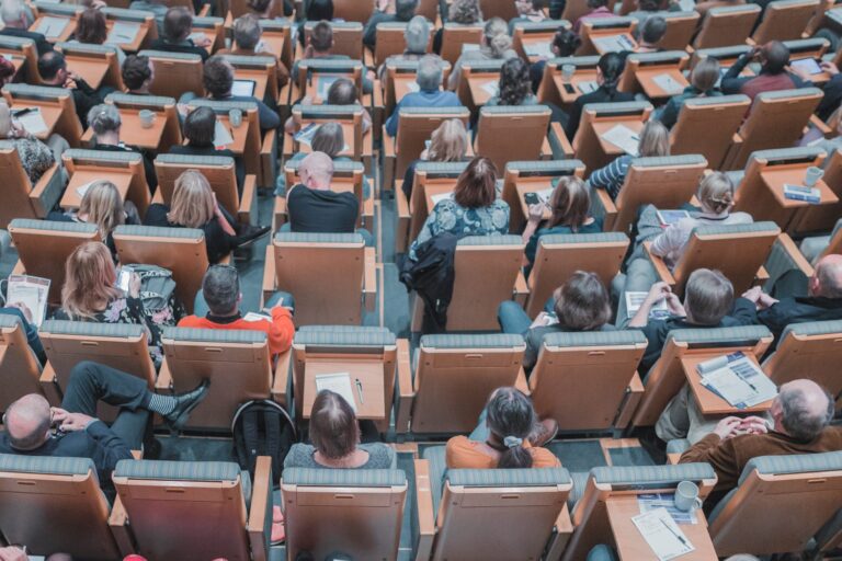 People sitting in a lecture hall as seen from the back