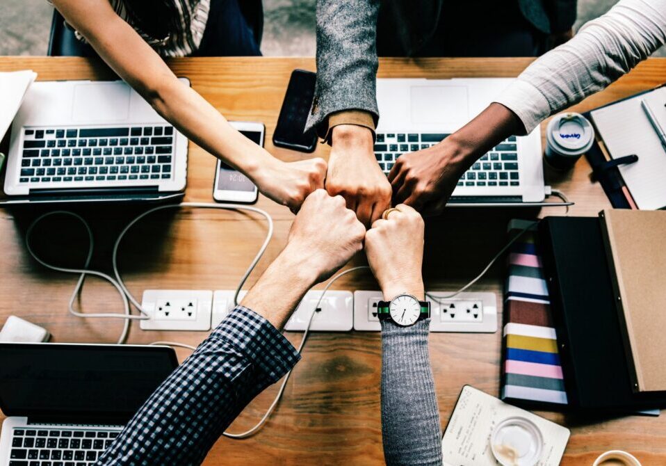 Overhead view of a five-way fist bump in an office