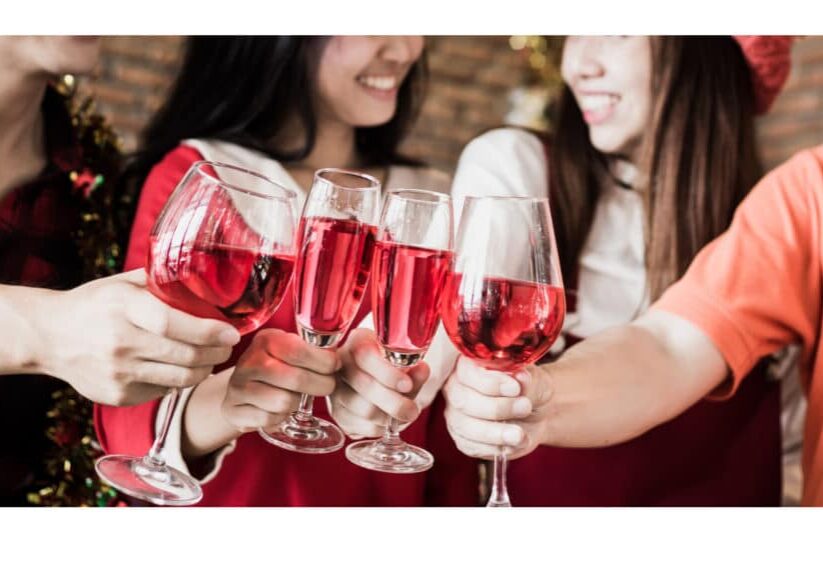 Several glasses of red wine coming together in a toast