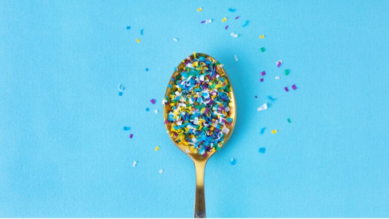 Spoon filled with small, colored bits of micro plastics