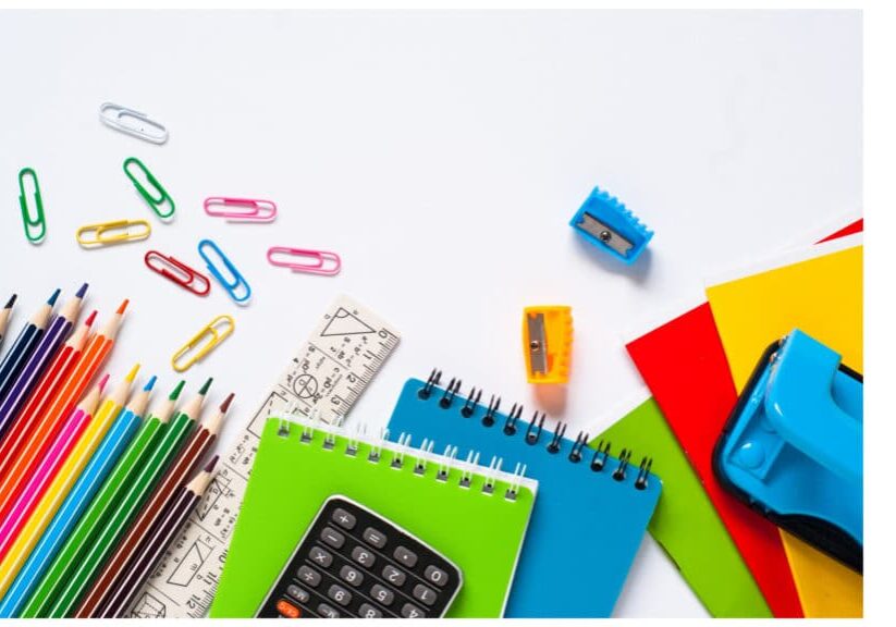 Notebooks and office supplies scattered on a white surface
