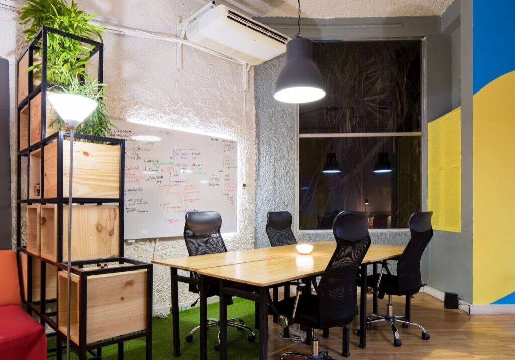 Office meeting room with large table and black office chairs.