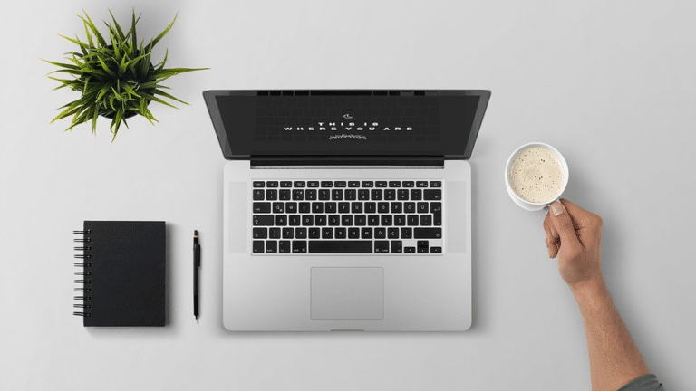 Overhead view of an open laptop on a grey desk